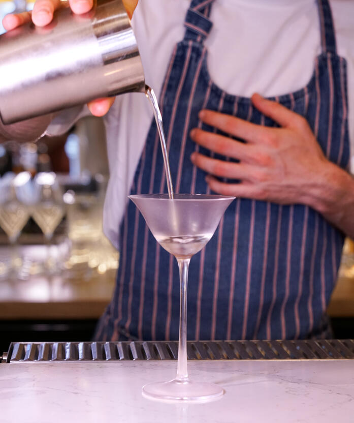 Dry Martini versé dans un verre à martini par un barman de Néroli